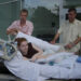 Hannah as a teenager laying in her hospital bed with her brother, Ben and Dad outside the hospital in central London.
