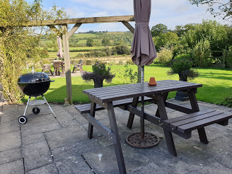 A bench with a cut out space for a wheelchair user to be able to sit up to the bench with the party.