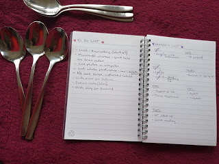A notebook with a to-list on it and several spoons to the left and above. To illustrate the art of pacing.