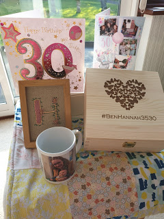 Hannah's 30th Birthday gifts A homemade patchwork quilt with a wooden box with butterflies in the shape of a heart and the words #BenHannah3530 on it. There are several 30th birthday cards and a photo mug next to the box.