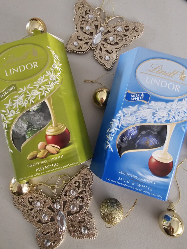 Two boxes of Lindor chocolates surrounded by Christmas baubles.